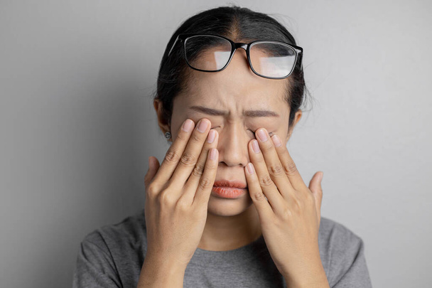 Frauen tragen eine Brille und leiden unter Augenschmerzen - Foto, Bild
