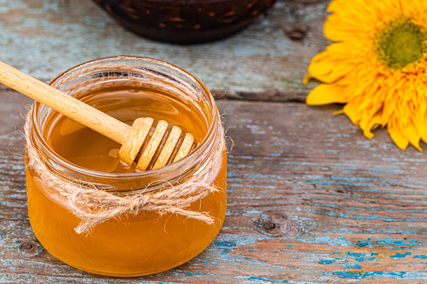 Honey background. Fresh honey in the pot with sunflower flower - Fotó, kép