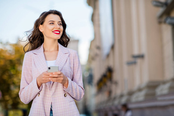 Portrait of her she nice-looking attractive lovely charming pretty shine winsome cheerful cheery wavy-haired girl red lips spending free time using cell app 5g service in downtown outdoors - 写真・画像