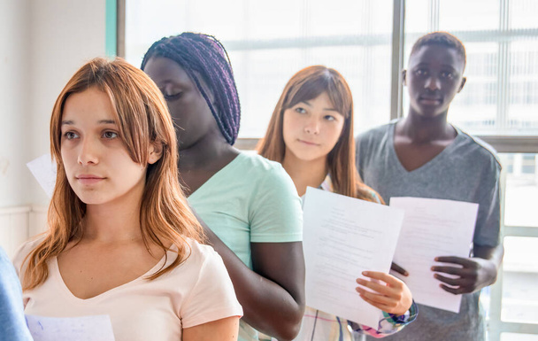 Group of multi ethnic teenagers delivering school test. - Foto, afbeelding