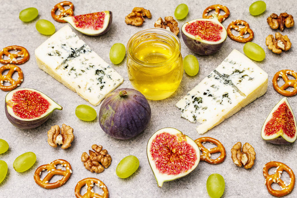 Sélection d'apéritifs au fromage ou ensemble de collations au vin. Bleu fromage, figues, miel, noix, bretzels
 - Photo, image