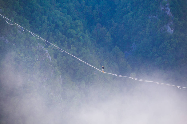 Highliner gaat op een sling boven de wolken. - Foto, afbeelding