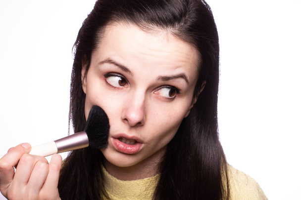 attractive girl does makeup, makeup brush - Foto, imagen