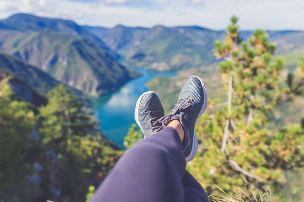 Female feet selfie on the top of the hill enjoying the view on river or lake canyon. Freedom concept. - Fotó, kép