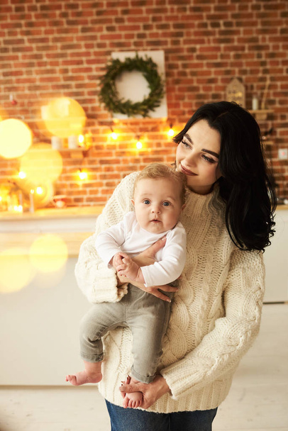 A beautiful young mother with a baby in a Christmas decorated ro - Fotografie, Obrázek