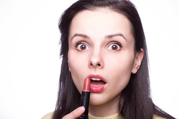 beautiful young woman paints lips with lipstick - Фото, зображення