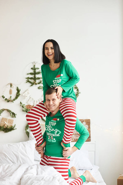Happy young romantic caucasian couple wear pajamas having fun la - Zdjęcie, obraz