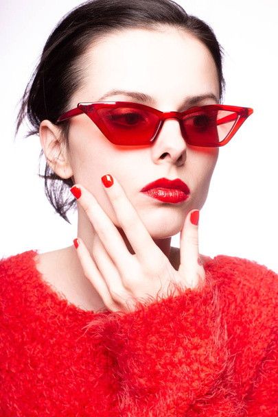 young woman in red sunglasses, red lipstick, red sweater - Фото, изображение