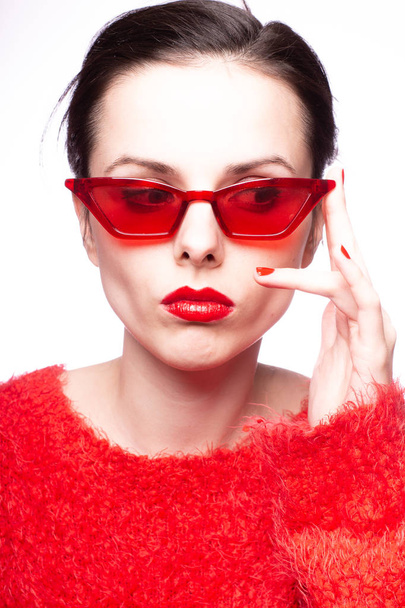 young woman in red sunglasses, red lipstick, red sweater - Fotoğraf, Görsel