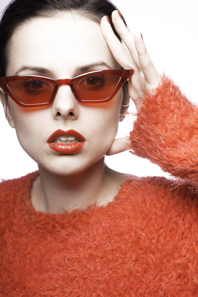 young woman in red sunglasses, red lipstick, red sweater - Фото, изображение