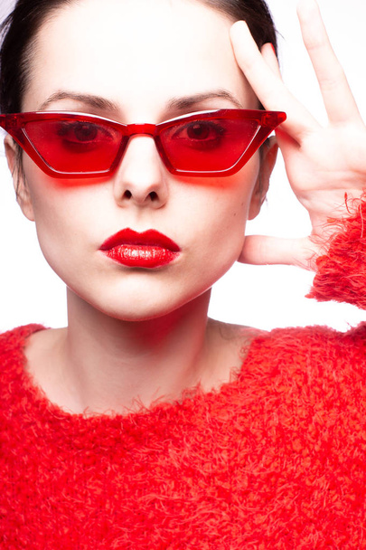 young woman in red sunglasses, red lipstick, red sweater - 写真・画像