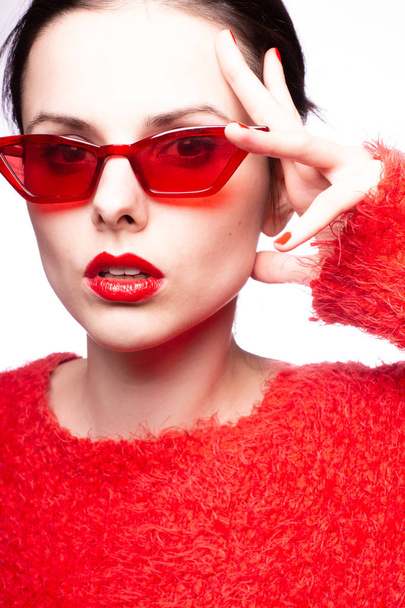 young woman in red sunglasses, red lipstick, red sweater - 写真・画像