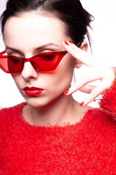 young woman in red sunglasses, red lipstick, red sweater - Foto, Bild