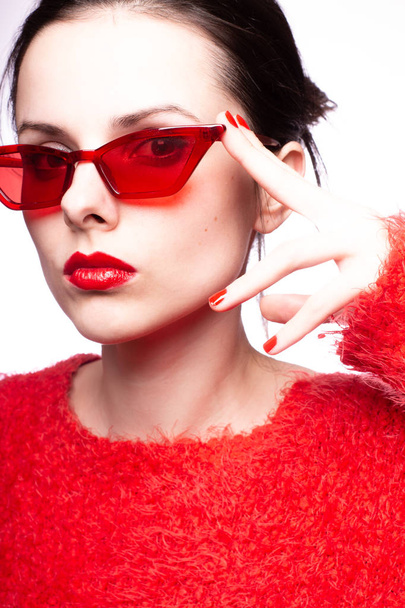 young woman in red sunglasses, red lipstick, red sweater - Fotó, kép