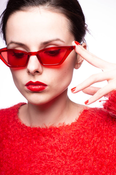 young woman in red sunglasses, red lipstick, red sweater - Foto, Imagen