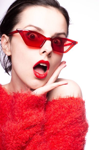 young woman in red sunglasses, red lipstick, red sweater - Photo, image
