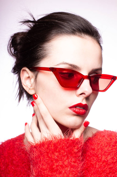 young woman in red sunglasses, red lipstick, red sweater - Photo, image