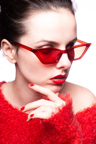 junge Frau mit roter Sonnenbrille, rotem Lippenstift, rotem Pullover - Foto, Bild