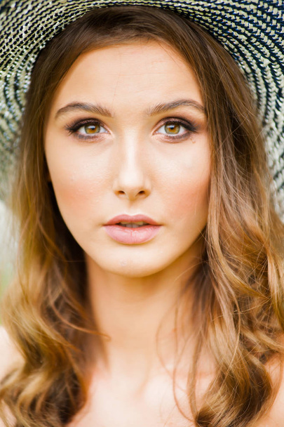 Νεαρή όμορφη Ευρωπαία γυναίκα σε καπέλο παραλίας στις διακοπές - Φωτογραφία, εικόνα