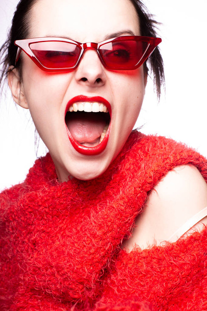young woman in red sunglasses, red lipstick, red sweater - Foto, immagini