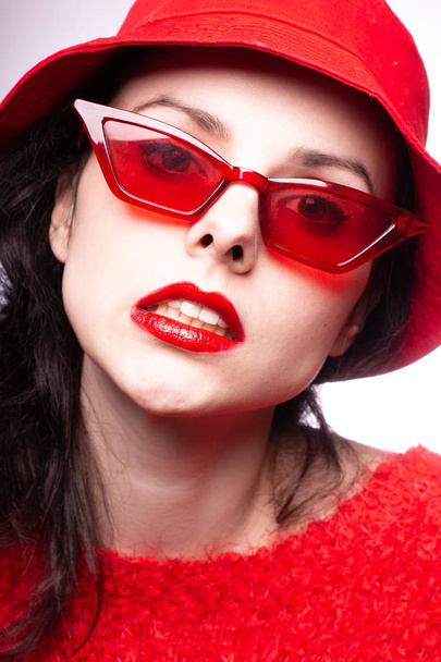 young woman in red sunglasses, red lipstick, red sweater - Foto, Imagem