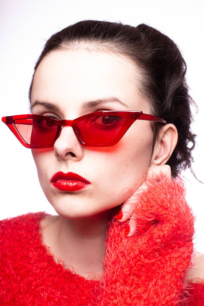 young woman in red sunglasses, red lipstick, red sweater - Valokuva, kuva