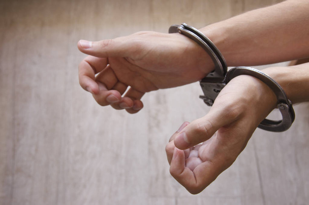 close-up of hands in handcuffs, the prisoner guy the arrested man handcuffed hands. - Fotó, kép