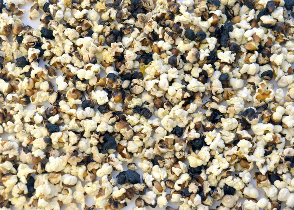 Popcorn brannte auf weißem Hintergrund. Verdorbenes Essen - Foto, Bild