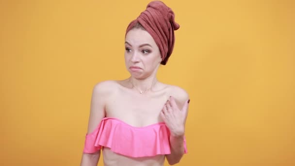 young girl with towel on her head over isolated orange background shows emotions - 映像、動画