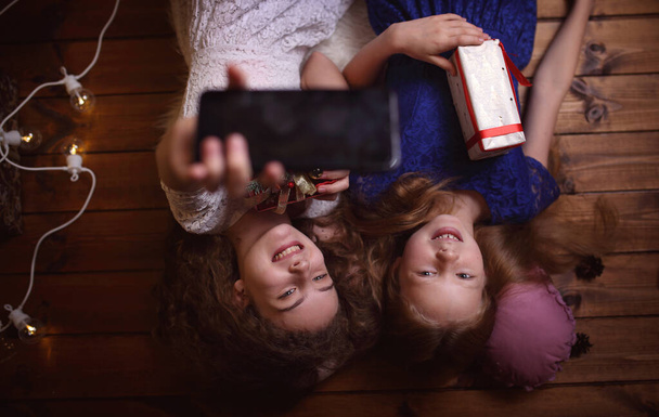 Young friends take a selfie with a phone and Christmas presents - Zdjęcie, obraz