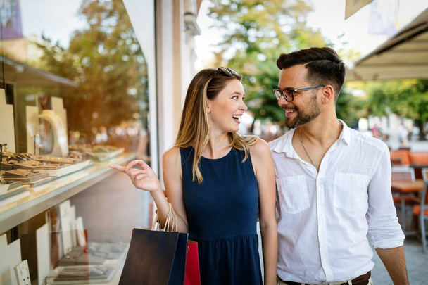 Consumerism, love, dating, travel concept. Happy couple enjoying shopping having fun - Φωτογραφία, εικόνα