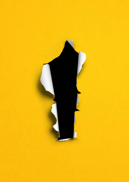 Yellow torn paper with black hole - Фото, зображення