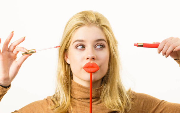Woman applying lipstick or lip gloss - Foto, afbeelding