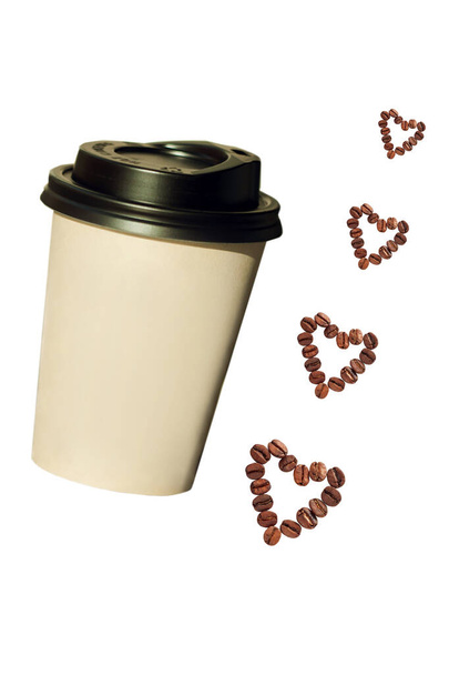 Паперова чашка з кавовими зернами у формі серця ізольована на білому тлі
. - Фото, зображення