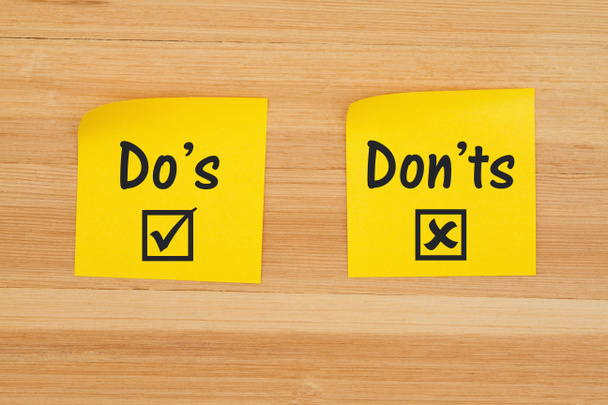 Do's and Don'ts on two sticky notes on textured wood desk - Photo, Image