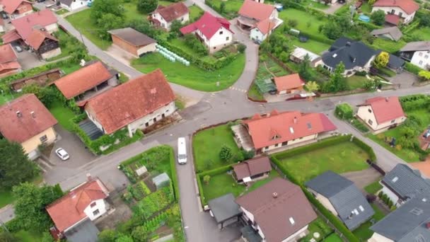 We can see a white van which is driving backwards. Aerial shot. The neighbourhoods are beautifully green. - Footage, Video