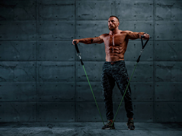 Ejercicio muscular atlético para hombres con banda de resistencia. Copiar espacio
 - Foto, imagen