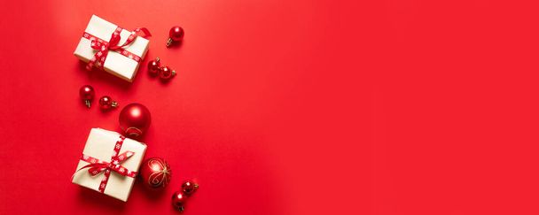 Joulun koostumus juhlava punainen veneet laatikot ja punainen nauhat ja pienet pallot punaisella pohjalla
. - Valokuva, kuva