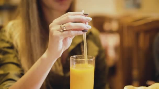 Happy girl tasting the mango juice and smiling in cafe - Video