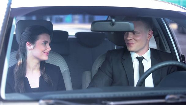 Gülümseyen ve arabada flört eden neşeli bir çift, ilk buluşmada romantizm. - Fotoğraf, Görsel