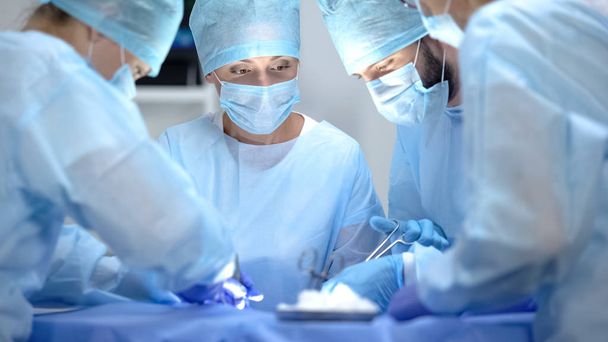 Equipo serio de cirujanos que realizan cirugía cardiotorácica, operación hospitalaria
 - Foto, Imagen