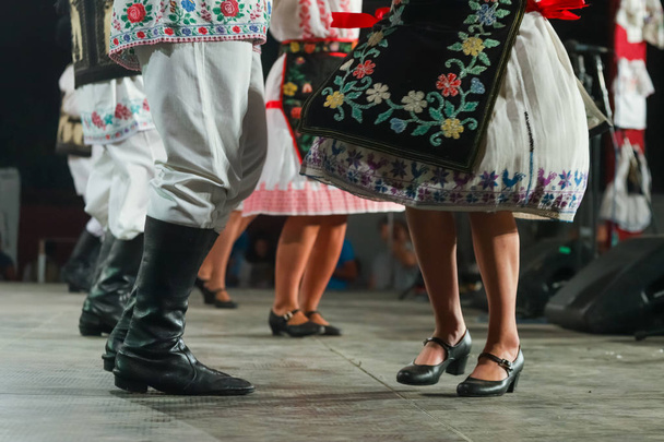 Primer plano de las piernas de las jóvenes bailarinas rumanas y masculinas en traje folclórico tradicional. Folklore de Rumania
 - Foto, Imagen