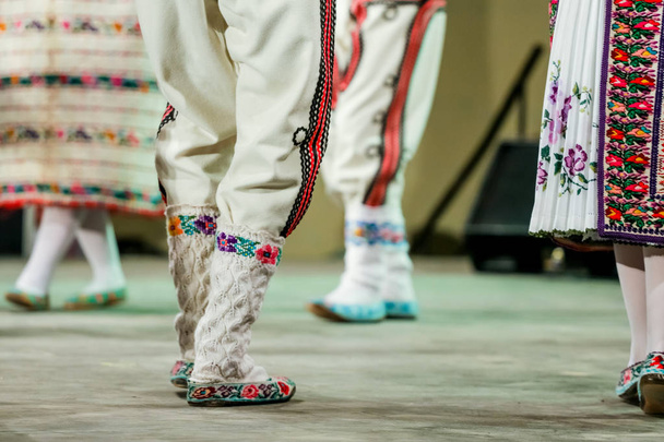 Zbliżenie wełniane skarpetki na nogi młodego rumuńskiego tancerza w tradycyjnym stroju folklorystycznym. Folklor Rumunii - Zdjęcie, obraz