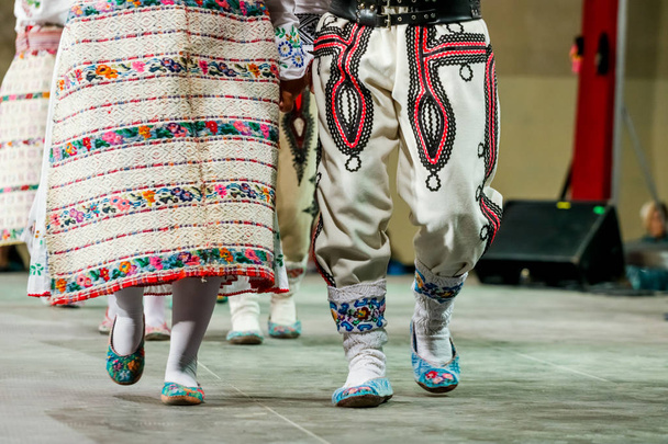 Κοντινό πλάνο μάλλινων καλτσών στα πόδια νεαρών Ρουμάνων γυναικών και ανδρών χορευτών με παραδοσιακή λαϊκή ενδυμασία. Λαογραφία της Ρουμανίας - Φωτογραφία, εικόνα