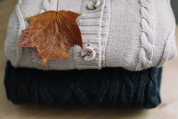 Background with knitted clothes and autumn leaves, warm background, knitwear, space for text, Autumn winter concept.  - Fotoğraf, Görsel