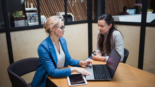 young HR woman interviews a candidate for a job. Business meeting two young women at work discussing the project - 写真・画像