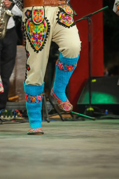 Κοντινό πλάνο μπλε μάλλινες κάλτσες στα πόδια νεαρών Ρουμάνων χορευτών με παραδοσιακή λαϊκή ενδυμασία. Λαογραφία της Ρουμανίας - Φωτογραφία, εικόνα
