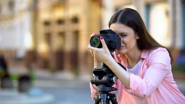 Professional female photographer focusing camera objective, photo shooting - 写真・画像