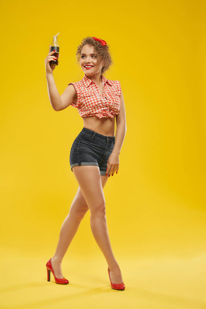 Happy girl posing at camera with bottle of soda in hand - Φωτογραφία, εικόνα