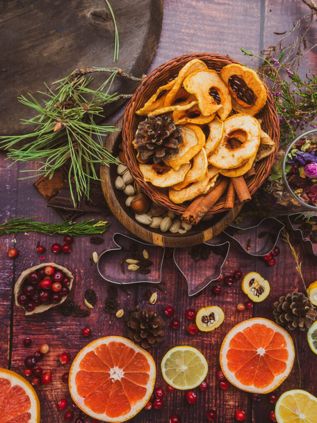 Holiday food background for baking cookies with cutters, spices, fruits, cranberries, nuts, dried apples, chocolate, raisin, on vintage table top view. - Fotó, kép